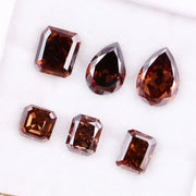 Set of premium brown lab-grown diamonds in emerald, pear, and octagon cuts displaying rich fancy color and brilliant faceting for custom fine jewelry designs.