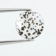Close-up of a unique lab-grown diamond featuring distinct black carbon inclusions, showcasing its natural beauty and sustainable origins.