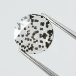 Close-up of a unique lab-grown diamond featuring distinct black carbon inclusions, showcasing its natural beauty and sustainable origins.