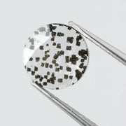 Close-up of a unique lab-grown diamond featuring distinct black carbon inclusions, showcasing its natural beauty and sustainable origins.