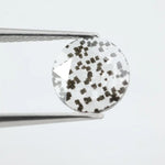 Close-up of a unique lab-grown diamond featuring distinct black carbon inclusions, showcasing its natural beauty and sustainable origins.
