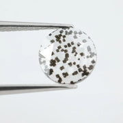 Close-up of a unique lab-grown diamond featuring distinct black carbon inclusions, showcasing its natural beauty and sustainable origins.
