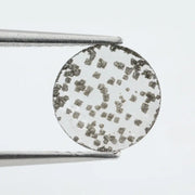 Close-up of a unique lab-grown diamond featuring distinct black carbon inclusions, showcasing its natural beauty and sustainable origins.