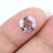 Close-up of a unique lab-grown diamond featuring distinct black carbon inclusions, showcasing its natural beauty and sustainable origins.