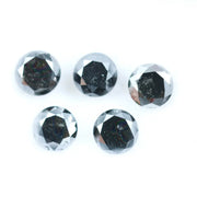Five natural round cut black diamonds with faceted surfaces showing natural inclusions and dark carbon tones, loose untreated genuine diamonds suitable for custom jewelry making.