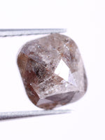 cushion cut diamond held by tweezers on a white background
