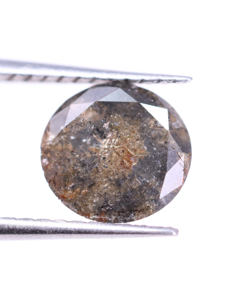 Brown diamond held between tweezers on a white background