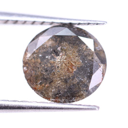 Brown diamond held between tweezers on a white background
