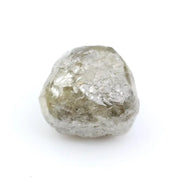 Raw diamond crystal inspected under bright lighting.