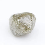 Raw diamond crystal inspected under bright lighting.