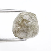 Raw diamond crystal inspected under bright lighting.