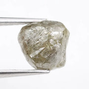 Raw diamond crystal inspected under bright lighting.