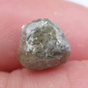 Raw diamond crystal inspected under bright lighting.
