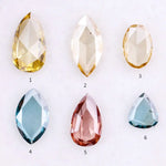 Six lab grown colored diamonds displayed on white background featuring pear, marquise and oval cuts in fancy yellow, champagne, blue and pink shades, ideal for custom engagement rings and fine jewelry settings.