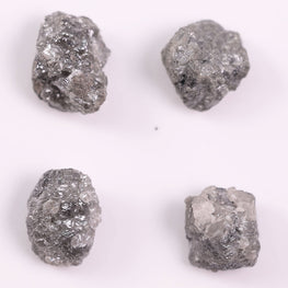 Four rough gray diamonds on a white background