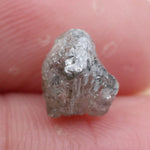 Large raw gemstones and rough diamond crystals displayed together.