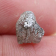 Large raw gemstones and rough diamond crystals displayed together.