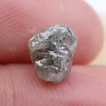 Large raw gemstones and rough diamond crystals displayed together.