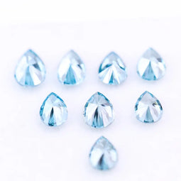 Eight vivid blue pear cut lab grown diamonds displayed on white background, featuring brilliant faceting, teardrop shape, and rich ocean blue tones ideal for custom engagement rings and fine jewelry.