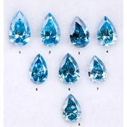Eight vivid blue pear cut lab grown diamonds displayed on white background, featuring brilliant faceting, teardrop shape, and rich ocean blue tones ideal for custom engagement rings and fine jewelry.