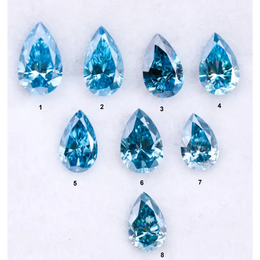 Eight vivid blue pear cut lab grown diamonds displayed on white background, featuring brilliant faceting, teardrop shape, and rich ocean blue tones ideal for custom engagement rings and fine jewelry.