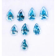Eight vivid blue pear cut lab grown diamonds displayed on white background, featuring brilliant faceting, teardrop shape, and rich ocean blue tones ideal for custom engagement rings and fine jewelry.