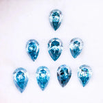 Eight vivid blue pear cut lab grown diamonds displayed on white background, featuring brilliant faceting, teardrop shape, and rich ocean blue tones ideal for custom engagement rings and fine jewelry.