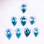 Eight vivid blue pear cut lab grown diamonds displayed on white background, featuring brilliant faceting, teardrop shape, and rich ocean blue tones ideal for custom engagement rings and fine jewelry.