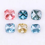 Six cushion cut lab grown diamonds in fancy colors including deep teal, vivid blue, pink, yellow, and light blue displayed on white background for fine jewelry design.
