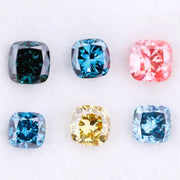 Six cushion cut lab grown diamonds in fancy colors including deep teal, vivid blue, pink, yellow, and light blue displayed on white background for fine jewelry design.
