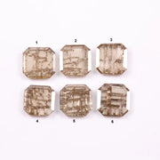 Six emerald cut lab grown diamonds with soft champagne color and visible internal growth pattern inclusions, arranged in two rows and numbered 1 through 6 on a white background.