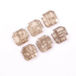 Six emerald cut lab grown diamonds with soft champagne color and visible internal growth pattern inclusions, arranged in two rows and numbered 1 through 6 on a white background.