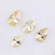 Four fancy yellow lab grown diamonds in pear and oval brilliant cuts displayed on white background, showcasing vivid yellow color, high clarity, and precision faceting.