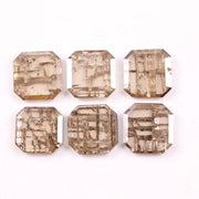 Six emerald cut lab grown diamonds with soft champagne color and visible internal growth pattern inclusions, arranged in two rows and numbered 1 through 6 on a white background.