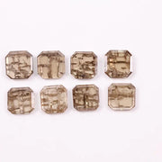 Emerald step cut lab grown diamonds with champagne tone and visible natural-style inclusions arranged in two rows on a white background.
