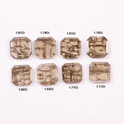 Emerald step cut lab grown diamonds with champagne tone and visible natural-style inclusions arranged in two rows on a white background.