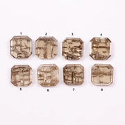 Emerald step cut lab grown diamonds with champagne tone and visible natural-style inclusions arranged in two rows on a white background.