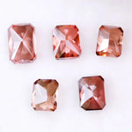 Five emerald cut lab grown fancy red pink diamonds displayed on white background, octagon step cut synthetic CVD diamonds in various deep red and blush tones for fine jewelry use.