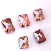 Five emerald cut lab grown fancy red pink diamonds displayed on white background, octagon step cut synthetic CVD diamonds in various deep red and blush tones for fine jewelry use.