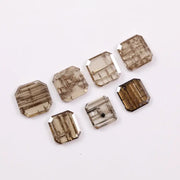 Emerald cut lab grown diamond featuring natural-inspired linear inclusions in a step cut octagonal shape, showcasing warm champagne tones and geometric internal patterns on a clean white background.