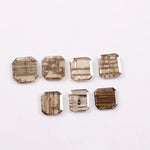Emerald cut lab grown diamond featuring natural-inspired linear inclusions in a step cut octagonal shape, showcasing warm champagne tones and geometric internal patterns on a clean white background.