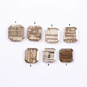 Emerald cut lab grown diamond featuring natural-inspired linear inclusions in a step cut octagonal shape, showcasing warm champagne tones and geometric internal patterns on a clean white background.