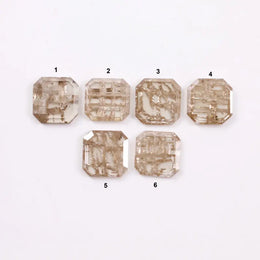 Six octagon step cut lab grown diamonds in fancy light champagne color with natural style inclusions, arranged on white background, ethically created loose stones for custom fine jewelry designs.