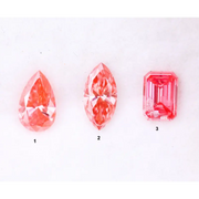 Three lab grown pink diamonds displayed on a white background, including a pear cut, marquise cut, and emerald cut fancy vivid pink loose diamonds for custom fine jewelry and engagement rings.