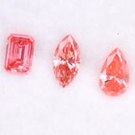 Three lab grown pink diamonds displayed on a white background, including a pear cut, marquise cut, and emerald cut fancy vivid pink loose diamonds for custom fine jewelry and engagement rings.
