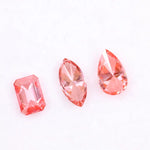 Three lab grown pink diamonds displayed on a white background, including a pear cut, marquise cut, and emerald cut fancy vivid pink loose diamonds for custom fine jewelry and engagement rings.