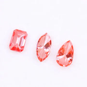 Three lab grown pink diamonds displayed on a white background, including a pear cut, marquise cut, and emerald cut fancy vivid pink loose diamonds for custom fine jewelry and engagement rings.