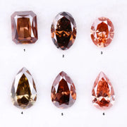 Six fancy colored lab grown diamonds in pink, peach, and cognac tones featuring emerald cut, oval cut, and pear cut shapes displayed on a white background, ethical CVD loose stones for custom fine jewelry.