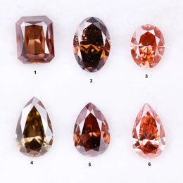 Six fancy colored lab grown diamonds in pink, peach, and cognac tones featuring emerald cut, oval cut, and pear cut shapes displayed on a white background, ethical CVD loose stones for custom fine jewelry.