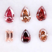 Six lab grown fancy colored diamonds in pink, blush, champagne and deep rose tones featuring pear, oval and emerald cuts displayed on a white background for fine jewelry design.